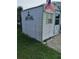 White storage shed with green trim and an American flag at 3090 Lockwood St, Port Charlotte, FL 33952
