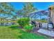 Landscaped backyard with screened patio and water view at 3179 Osprey Ln, Port Charlotte, FL 33953