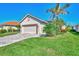 Single-story home with tan exterior, beige garage door, and landscaping at 3179 Osprey Ln, Port Charlotte, FL 33953