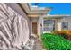 Front entry with a brown door, brick walkway, and lush green shrubbery at 3179 Osprey Ln, Port Charlotte, FL 33953