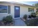 Inviting front door with blue paint, landscaping, and a short walkway at 445 Stewart St, Englewood, FL 34223