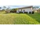 Large grassy backyard with a view of the home's exterior at 611 Chestnut Ln, Englewood, FL 34223