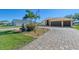 House with a three-car garage, paver driveway, and fountain at 634 Boundary Blvd, Rotonda West, FL 33947