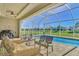 Relaxing pool and patio area with wicker furniture, overlooking a tranquil landscape at 634 Boundary Blvd, Rotonda West, FL 33947