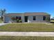 Single-story house with attached garage, landscaping, and a teal front door at 6379 Coliseum Blvd, Port Charlotte, FL 33981