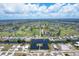 Vibrant aerial view of a residential community with waterways, golf courses, and a sunny sky at 76 Long Meadow Ct, Rotonda West, FL 33947