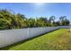 Fenced-in backyard with a lush green lawn surrounded by beautiful mature trees at 76 Long Meadow Ct, Rotonda West, FL 33947