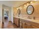 Bathroom boasting dual sinks, granite countertops, and travertine tile walls at 76 Long Meadow Ct, Rotonda West, FL 33947