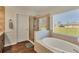 Updated bathroom with a soaking tub, walk-in shower, and wood-look tile at 76 Long Meadow Ct, Rotonda West, FL 33947