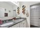 Bathroom with double vanity, granite countertop, and decorative shelving at 9157 Genesee St, Port Charlotte, FL 33981