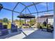 The screened-in patio includes an outdoor kitchen, comfortable lounge seating, and beautiful backyard views at 9157 Genesee St, Port Charlotte, FL 33981