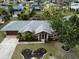 Aerial view of a single-Gathering home with a gray roof and landscaped yard at 97 Mariner Ln, Rotonda West, FL 33947
