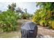 Spacious backyard with covered grill and tropical plants at 97 Mariner Ln, Rotonda West, FL 33947