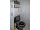Bathroom with black toilet and wicker shelving unit at 97 Mariner Ln, Rotonda West, FL 33947