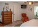 Bedroom with wicker dresser, armchair, and TV at 97 Mariner Ln, Rotonda West, FL 33947