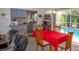 Dining room with a red tablecloth, wooden chairs and a view of the pool at 97 Mariner Ln, Rotonda West, FL 33947