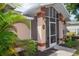 Close-up of the house entrance with a screened porch and landscaping at 97 Mariner Ln, Rotonda West, FL 33947