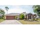 House with a two-car garage and a manicured lawn at 97 Mariner Ln, Rotonda West, FL 33947