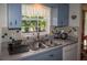 Kitchen with light blue cabinets, double sink, and a view of the backyard at 97 Mariner Ln, Rotonda West, FL 33947