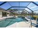 Spacious pool and patio area with screened enclosure, lounge chairs, and a tranquil view at 1071 Owl Dr, Englewood, FL 34223