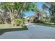 Long driveway leading to a home nestled in tropical landscaping at 1155 Forest Dr, Englewood, FL 34223