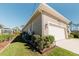 Rear view of tan house with white garage door and AC unit at 122 Glades Dr, Rotonda West, FL 33947