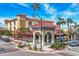 Building exterior featuring Spanish-style architecture, outdoor seating, and street-level parking at 1255 Tarpon Center Dr # 303, Venice, FL 34285