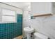 Bathroom with tiled walls, modern fixtures, and a pedestal sink at 1305 Rocky Creek Ln, Englewood, FL 34224