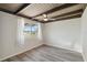 Bright bedroom with wood-look flooring, beamed ceiling, and ample natural light at 1305 Rocky Creek Ln, Englewood, FL 34224