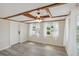 Open-concept living area with a ceiling fan, light vinyl floors, and wood beam ceiling at 1305 Rocky Creek Ln, Englewood, FL 34224