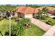 Aerial view of single-story house with tile roof, landscaping, and paved driveway at 13091 Creekside Ln, Port Charlotte, FL 33953