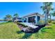 Landscaped backyard with a patio and tranquil lake view at 13091 Creekside Ln, Port Charlotte, FL 33953