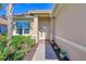 Inviting entryway with a brick-paved walkway, lush landscaping, and a light beige house exterior at 13091 Creekside Ln, Port Charlotte, FL 33953
