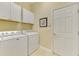 Practical laundry room with washer, dryer, and cabinets at 13091 Creekside Ln, Port Charlotte, FL 33953