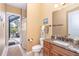 Well-lit bathroom featuring a granite countertop vanity and an open doorway to the lanai at 14010 San Domingo Blvd, Port Charlotte, FL 33981