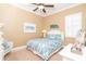 Cozy bedroom with a ceiling fan, shuttered window, and beach-themed decor at 14010 San Domingo Blvd, Port Charlotte, FL 33981