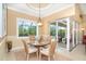 Elegant dining area with a glass table, seating for four, and natural light from the screened-in patio at 14010 San Domingo Blvd, Port Charlotte, FL 33981