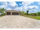 Spacious home featuring a large driveway, three-car garage, and lush front yard landscaping at 14010 San Domingo Blvd, Port Charlotte, FL 33981