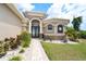Elegant home entrance with stone accents, beautiful landscaping, and decorative front door at 14010 San Domingo Blvd, Port Charlotte, FL 33981