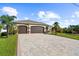 House exterior showcasing a three-car garage and a brick paved driveway at 14010 San Domingo Blvd, Port Charlotte, FL 33981