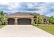 Charming single-story home featuring a three-car garage, well-manicured landscaping and a beautiful paver driveway at 14010 San Domingo Blvd, Port Charlotte, FL 33981