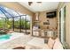Beautiful lanai with an outdoor kitchen, poolside seating, and serene views at 14010 San Domingo Blvd, Port Charlotte, FL 33981