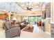 Spacious living room featuring a coffered ceiling, stone fireplace, and views of the pool at 14010 San Domingo Blvd, Port Charlotte, FL 33981