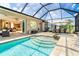 Enjoy this outdoor living space with pool, spa, and summer kitchen under a screened enclosure at 14010 San Domingo Blvd, Port Charlotte, FL 33981