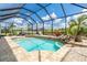 Gorgeous screened pool area with dining set, waterfall feature, and lounge seating at 14010 San Domingo Blvd, Port Charlotte, FL 33981