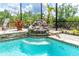 The sparkling pool features a charming rock waterfall, adding a touch of nature and relaxation to your backyard oasis at 14010 San Domingo Blvd, Port Charlotte, FL 33981