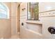 Close-up of a tiled walk-in shower featuring a built-in niche, an arched ceiling, and bronze fixtures at 14010 San Domingo Blvd, Port Charlotte, FL 33981