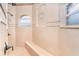 Spacious, tiled walk-in shower with built-in bench, arched window, and bronze fixtures at 14010 San Domingo Blvd, Port Charlotte, FL 33981