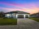 Single-story home with three-car garage, landscaping, and a neutral color palette at 14681 Keystone Blvd, Port Charlotte, FL 33981