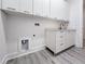 Modern laundry room with white cabinets and a utility sink at 14681 Keystone Blvd, Port Charlotte, FL 33981